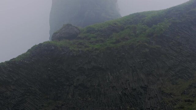 Misty Basalt Columns and Green Slopes in Iceland Mountain Landscape