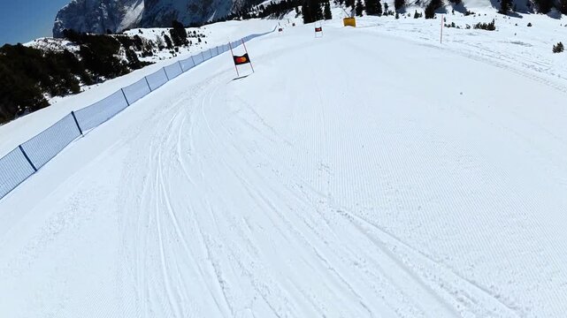Point of view of skier racing down a slalom course in the dolomites