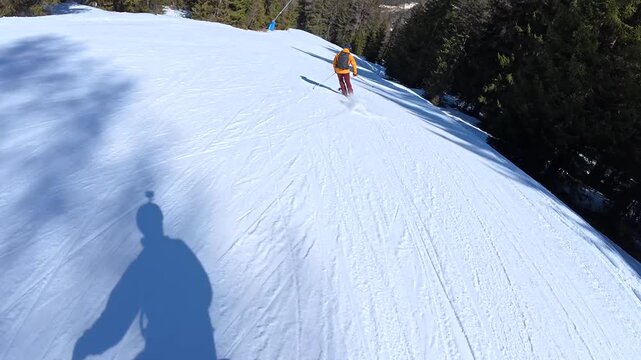 First person view skiing downhill on a sunny day