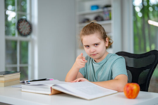 Child relaxing while reading a book at home. Teenager read book in a home interior. Little reader enjoying a story books at home. Kid reading book and learning in the playroom. Child holding a book.