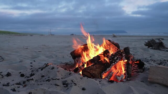 Campfire on cloudy beach at dusk Pacific Northwest 