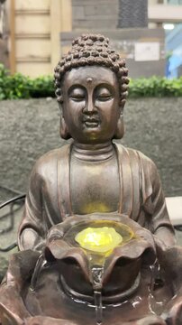 Buddha statue with glowing light holding lotus flower bowl