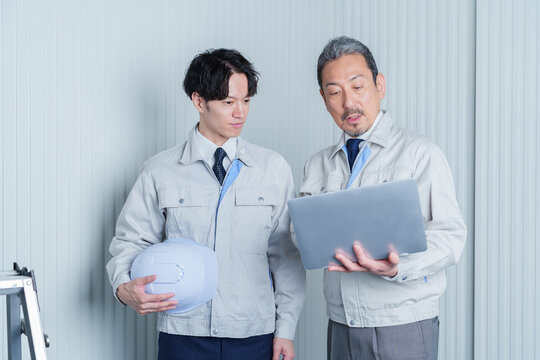 パソコンを使って現地調査をする作業員