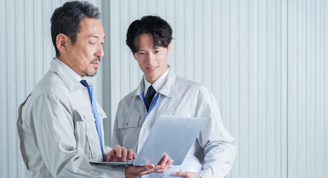 パソコンを使って現地調査をする作業員
