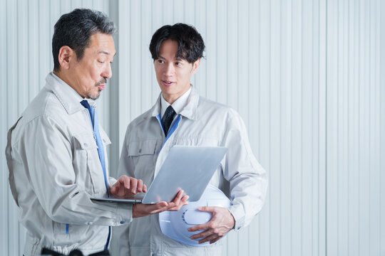 パソコンを使って現地調査をする作業員