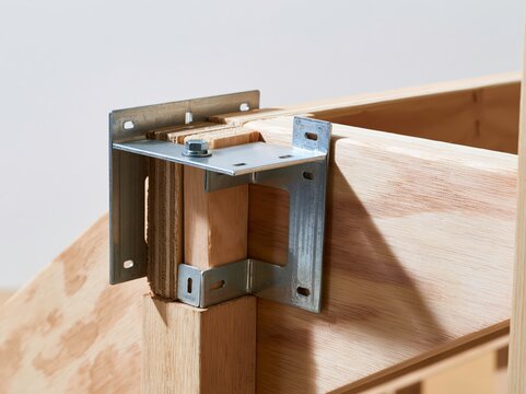 Stair stringer connector bracket fixed to the base of wooden stringers in a construction setting