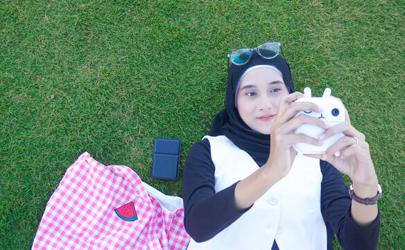 Creative portrait of a young Asian Muslim playfully with camera cute