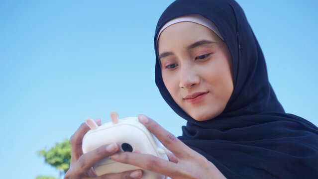 Creative portrait of a young Asian Muslim playfully with camera cute