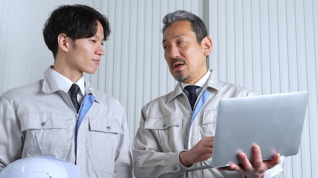 パソコンを使って現地調査をする作業員