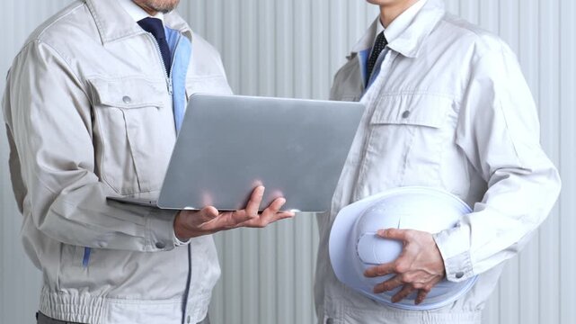 パソコンを使って現地調査をする作業員
