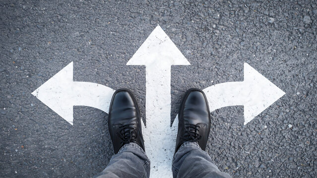 Business person standing at a three way intersection path decision point with decision direction business motivation strategy junction leadership opportunity navigation planning thinking