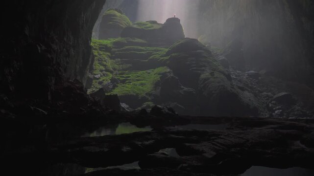 column of light shining on a person inside a big cave