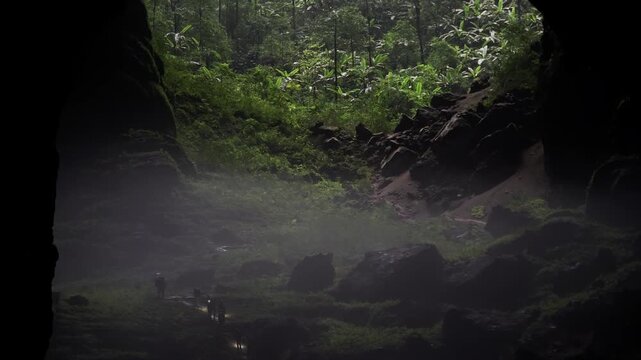 group of explorers walking through the mist head toward the green jungle above