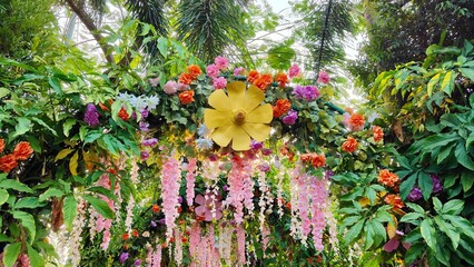 Colorful floral garden decoration with lush tropical greenery and hanging flowers, creating a vibrant outdoor backdrop for weddings, events, and nature themed celebrations. © Yangkasa
