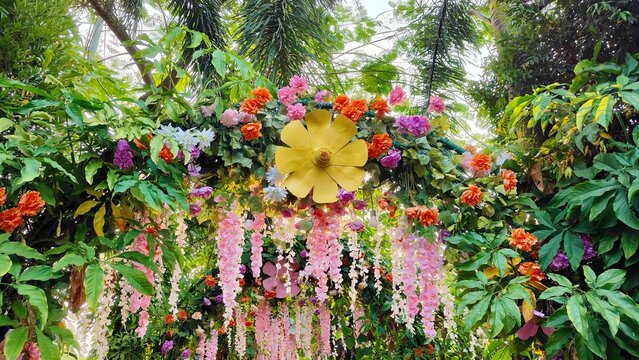 Colorful floral garden decoration with lush tropical greenery and hanging flowers, creating a vibrant outdoor backdrop for weddings, events, and nature themed celebrations.