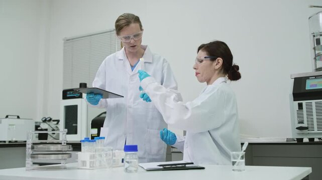 Professional female researcher opening centrifuge tube to examine sample in sterile cleanroom laboratory for medical healthcare, pharmaceutical research, and modern biotechnology innovation.
