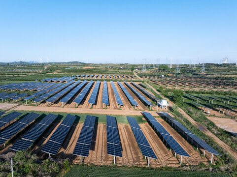 Large scale photovoltaic power station with solar panel arrays arranged between farmland fields
