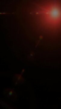 Orange glowing lens flare on dark black background