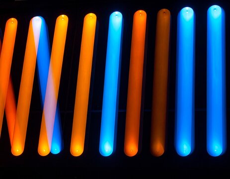 Row of light slits showing different color temperatures from warm orange to cool blue on dark background