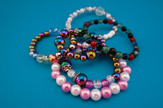 A collection of handmade beaded bracelets crafted from colorful decorative beads in various shapes, sizes, and finishes