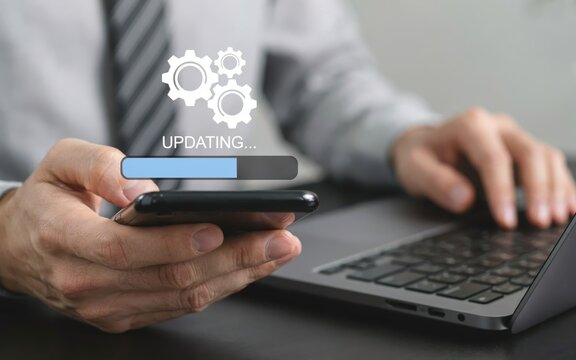 Businessman updating software on smartphone