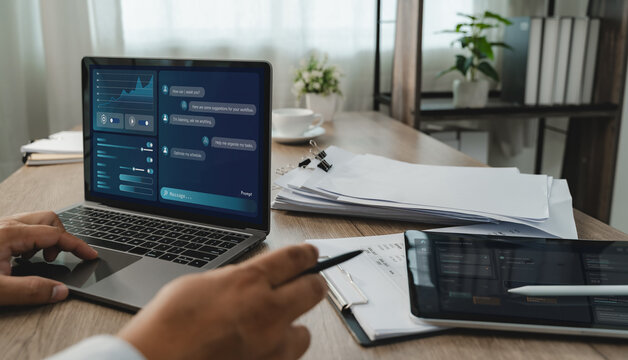 Person uses LLM-based AI chatbot software on a laptop documents, interacting with a digital AI Assisted Home Office interface to organize tasks and support an office workflow.