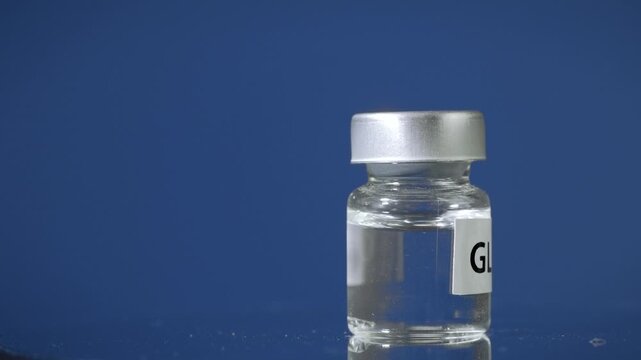 Clear medicine liquid in glass vial on blue background represents hopeful glp 1 hormone therapy injection treatment for diabetes obesity vaccine