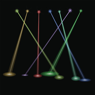 Colorful light beams shining from floor spots in a dark room creating abstract patterns