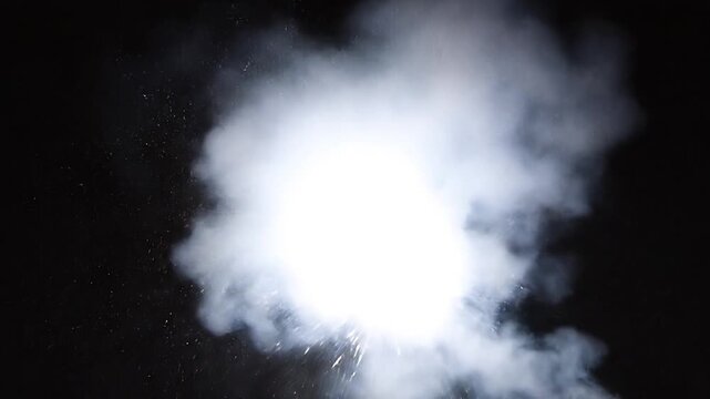 Watch bright white fireworks explode with brilliant sparks and smoke against a dark night sky. Perfect celebration video overlay.