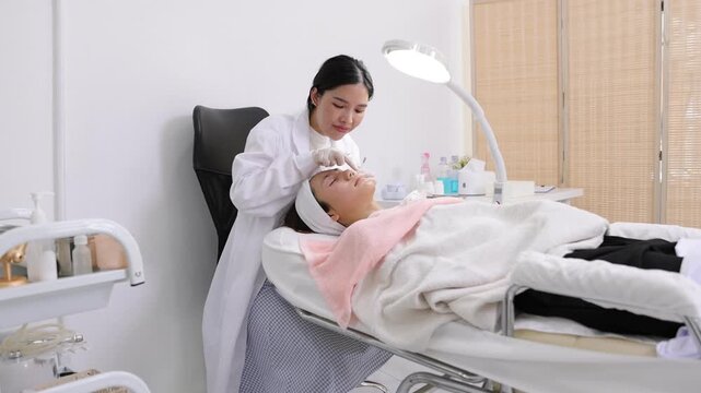 Dermatologist performing a facial acne treatment on a patient. Professional cosmetologist meticulously performing an acne extraction procedure on a young woman's face in a beauty clinic.