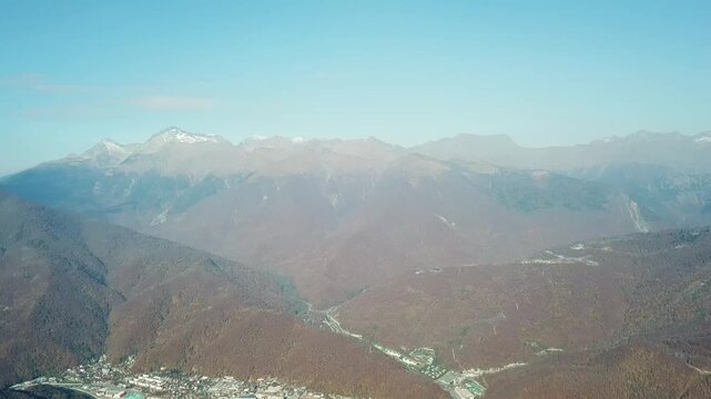 Aerial view of the autumn mountains and resort village in Estosadok, Krasnaya Polyana ski resort, Russia.
