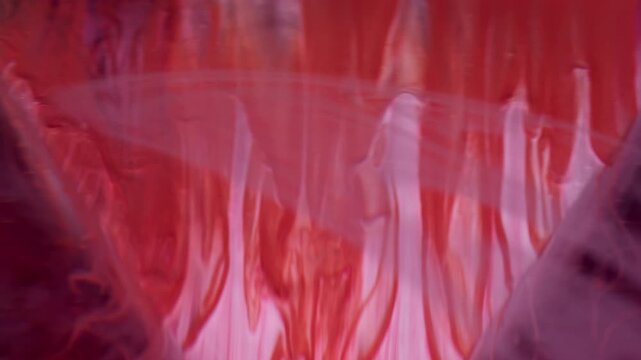 Paint wave. Geometric texture. Defocused pink red color ink in water acrylic liquid swirl moving on abstract dark black background.