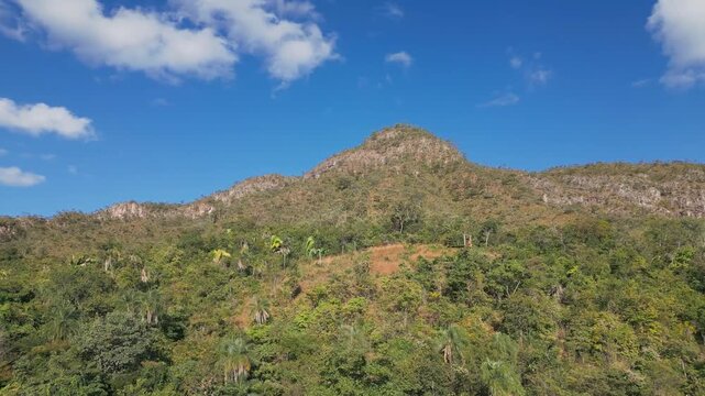 Quartzite ridge rises above the Sao Miguel River valley at Vale da Lua, Alto Paraiso de Goias, Chapada dos Veadeiros, Goias, Brazil, revealing rugged Cerrado highlands, drone orbit ascent parallax