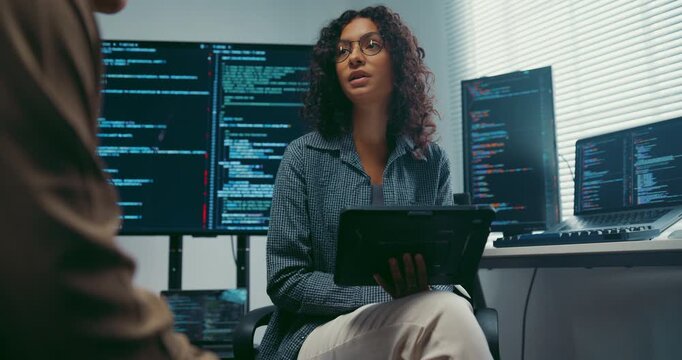 Diverse team developer uses tablet discuss AI coding and project strategy at office. Artificial intelligence software debugging, Cybersecurity database server, Machine learning app meeting concept.