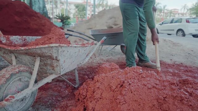 Bricklayer preparing a natural mixture of clay, soil, and straw. This sustainable building technique is perfect for bioconstruction