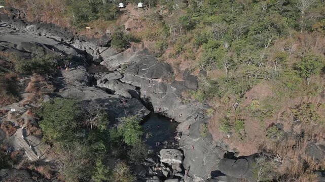 Sao Miguel River crosses the quartzite gorge of Vale da Lua, Alto Paraiso de Goias, Chapada dos Veadeiros, Goias, Brazil, surrounded by Cerrado vegetation, drone forward flyover descending.