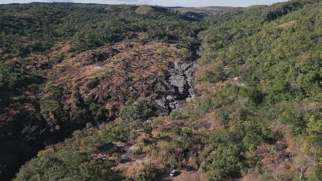 S&atilde;o Miguel River flows through the quartzite canyon of Vale da Lua, Alto Paraiso de Goias, Chapada dos Veadeiros, Goias, Brazil, surrounded by Cerrado vegetation, drone orbit.