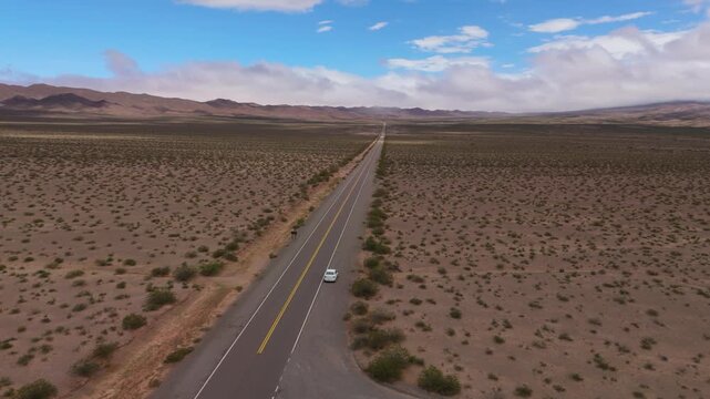 Drone orbit car parked on side of highway across open desert near Recta del Tin Tin, aerial