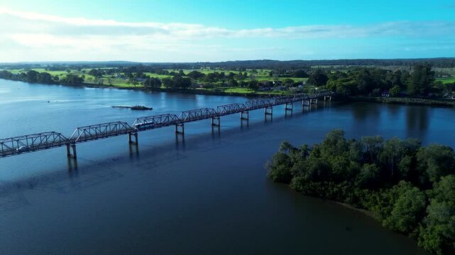 Drone aerial landscape of bus and car vehicles driving across the Martin Bridge over the Manning River inlet in Taree with rural countryside in the background on the Mid North Coast Australia travel