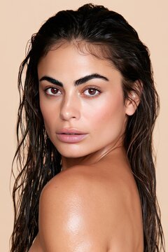 Natural Beauty Portrait of Woman with Wet Hair Against Neutral Background