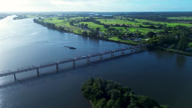 Drone aerial landscape of transport travelling along the Martin Bridge with the Manning River waterways and rural land in the background in Taree regional town in NSW Mid North Coast Australia tourism