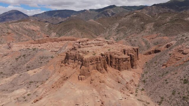 Drone ascend reveals landscape and ridges of Los Castillos sandstone formation in Quebrada de las Flechas, aerial