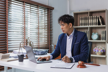 Obraz premium Lawyer working at desk with scales of justice and gavel