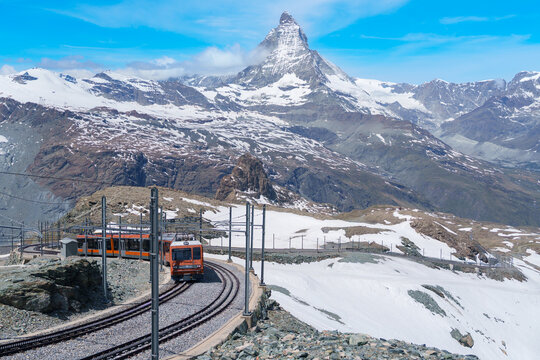 Iconic Matterhorn Mountain with Gornergrat Railway Train in Zermatt, Switzerland, Snow Capped Alpine Peak under Blue Sky, Famous Swiss Alps Landmark landscape and popular European Travel Destination