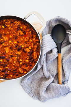 homemade vegetarian tempeh kidney bean chilli with corn in cooking pot