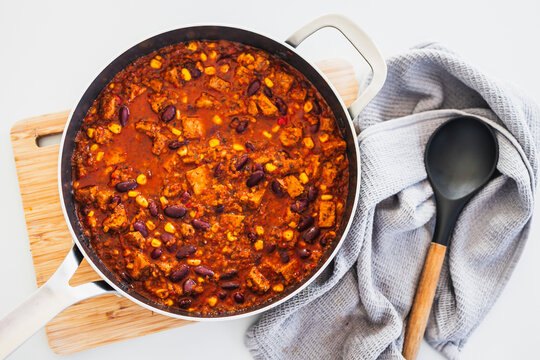 homemade vegetarian tempeh kidney bean chilli with corn in cooking pot