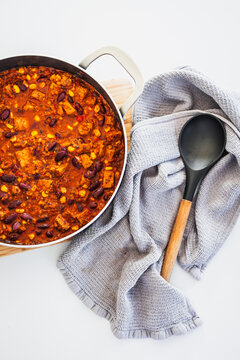homemade vegetarian tempeh kidney bean chilli with corn in cooking pot