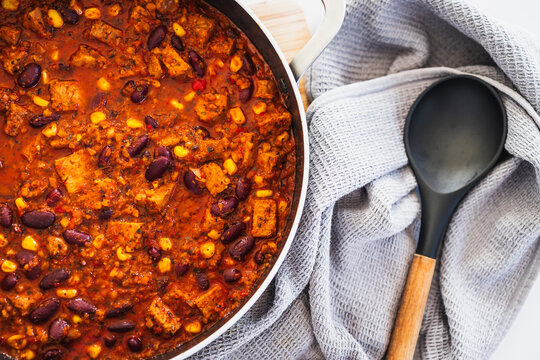 homemade vegetarian tempeh kidney bean chilli with corn in cooking pot