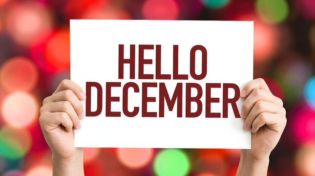 Hands holding a white paper sign with bold red Hello December text against a vibrant, blurred bokeh background of colorful lights and soft circular highlights featuring message