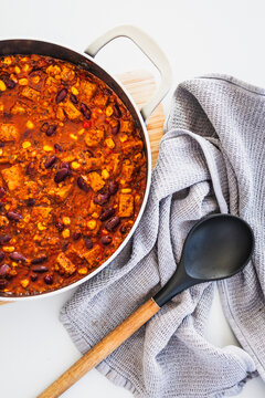 homemade vegetarian tempeh kidney bean chilli with corn in cooking pot